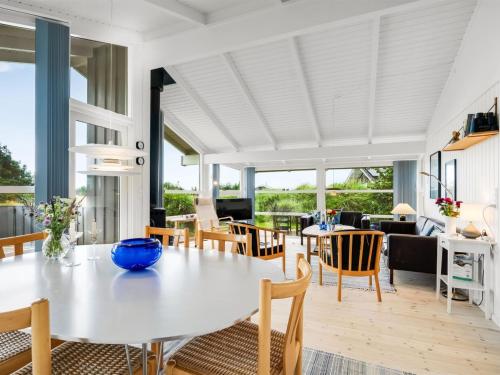 a dining room with a white table and chairs at Holiday Home Laurentius - 300m from the sea by Interhome in Torsted