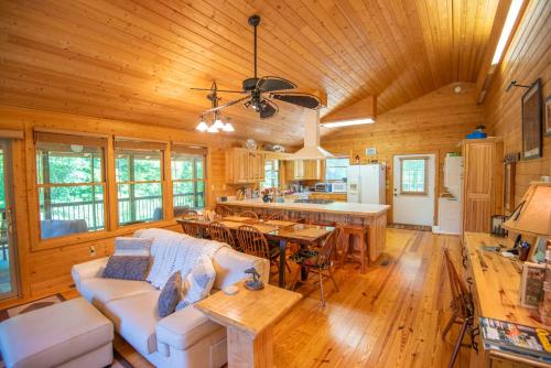 a living room with a white couch and a kitchen at Cabin at Cranberry Mill - Private Creekfront Cabin in Laurel Springs 
