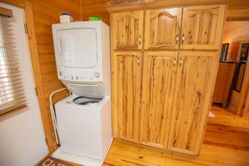 a kitchen with a washing machine and a washer at Cabin at Cranberry Mill - Private Creekfront Cabin in Laurel Springs 