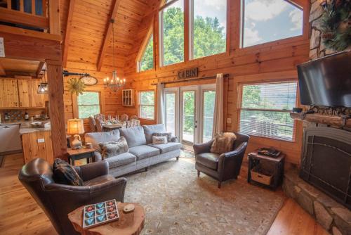 a living room with a couch and a tv in a cabin at Mnt Views, Close to Everything, Hot Tub, Sleeps 4 - Buena Vista Cabin in West Jefferson