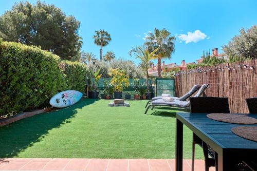 a backyard with a green lawn with a couch at Charming Bungalow in Venta Lanuza - by Welcomely in El Campello