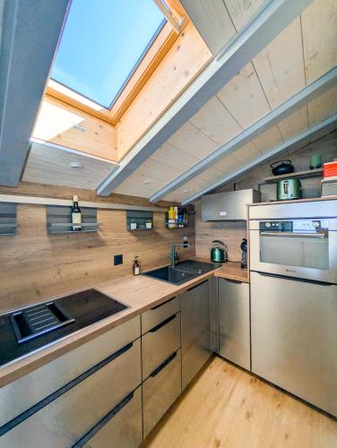a large kitchen with a skylight in the ceiling at Cocon familial avec vue au centre de Veysonnaz in Veysonnaz