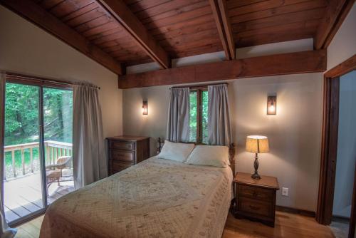 una camera da letto con un letto e un balcone di Private and Modern Blue Ridge Mountain Chalet- Sleeps 6 Dogs Welcome a Grassy Creek