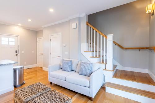 a living room with a white chair and stairs at The East Island Reserve Hotel in Middletown