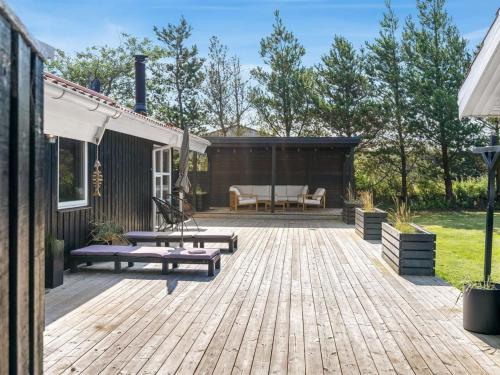 a backyard with a wooden deck with a picnic table at Holiday Home Ansfried - 900m from the sea by Interhome in Torsted