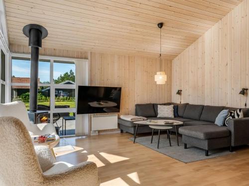 a living room with a couch and a tv at Holiday Home Ansfried - 900m from the sea by Interhome in Torsted
