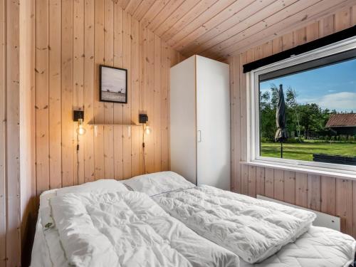 a bed in a room with a window at Holiday Home Ansfried - 900m from the sea by Interhome in Torsted