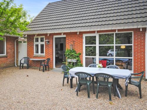 a table and chairs in front of a brick house at Holiday Home Ludovic - 7km from the sea by Interhome in Thisted