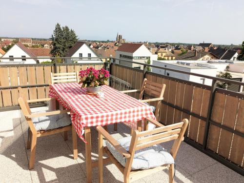 a table and chairs on a balcony with a table and flowers at Grape Escape - Appartement avec Terrasse et Garage in Rouffach