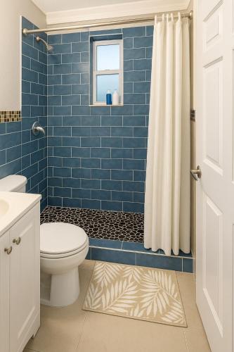 a blue tiled bathroom with a toilet and a window at Downtown Miami full apartment with kitchen in Miami