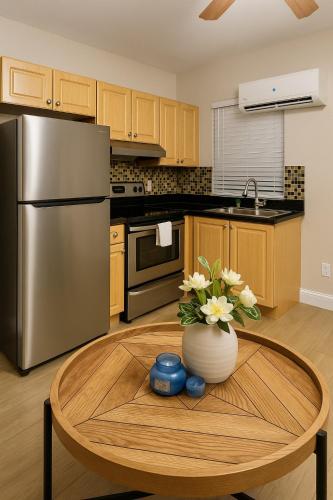 a kitchen with a refrigerator and a table with a vase of flowers at Downtown Miami full apartment with kitchen in Miami