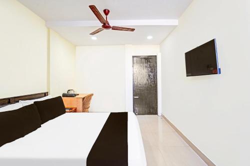 a bedroom with a bed and a ceiling fan at Super Collection O Guduvancheri Railway Station in Chennai
