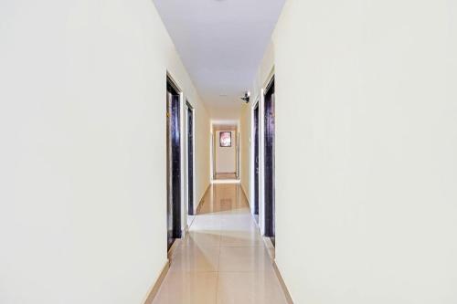 a hallway with white walls and tile floors at Super Collection O Guduvancheri Railway Station in Chennai