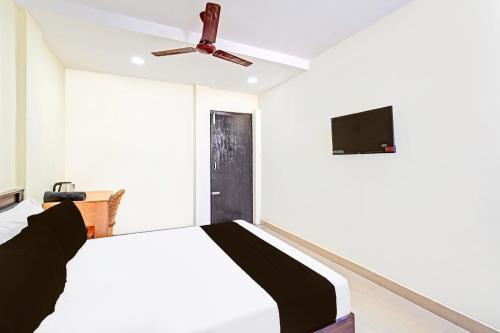 a bedroom with a bed and a ceiling fan at Super Collection O Guduvancheri Railway Station in Chennai