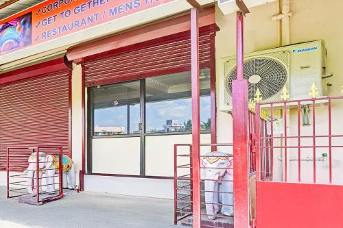 a store front with a red door and a fan at Super Collection O Guduvancheri Railway Station in Chennai
