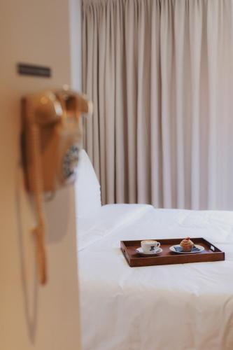a tray of food sitting on top of a bed at Man Met Bril Koffie Hotel in Rotterdam