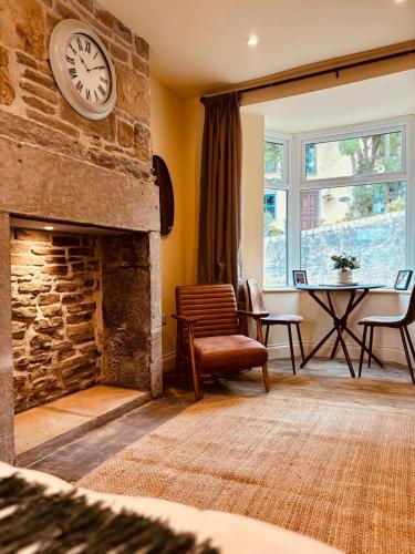 a living room with a stone fireplace with a clock on the wall at 8 Parker Street in Lancaster