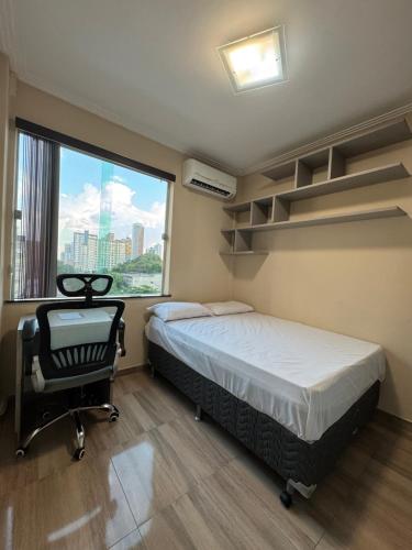 a bedroom with a bed and a chair and a window at Quartos Privativos e Transporte para COP30 in Belém