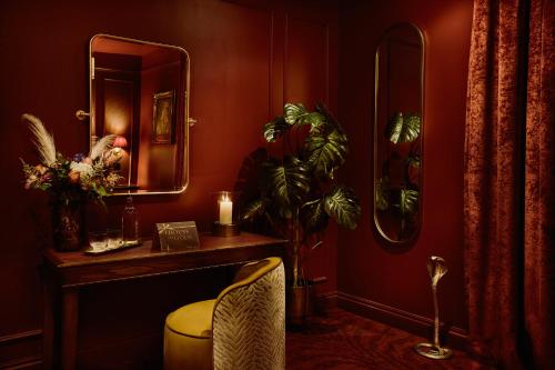 a room with a vanity with a mirror and a plant at House of Gods Canary Wharf in London
