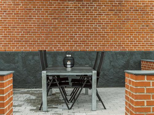 a table with a bird cage on it in front of a brick wall at Holiday Home Amely - 500m from the sea by Interhome in Sæby