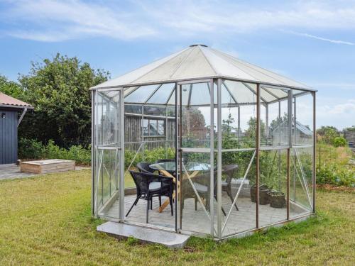 a greenhouse with a table and a chair in it at Holiday Home Amely - 500m from the sea by Interhome in Sæby