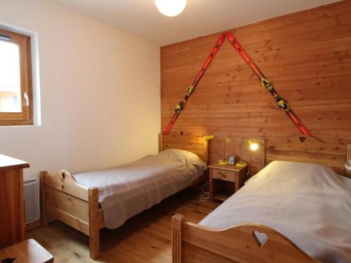 zwei Betten in einem Zimmer mit Holzwänden in der Unterkunft 3 pièces cosy : Jardin, Wifi, Parking, 700m des pistes, 50m des commerces - FR-1-572-44 in Arâches-la-Frasse