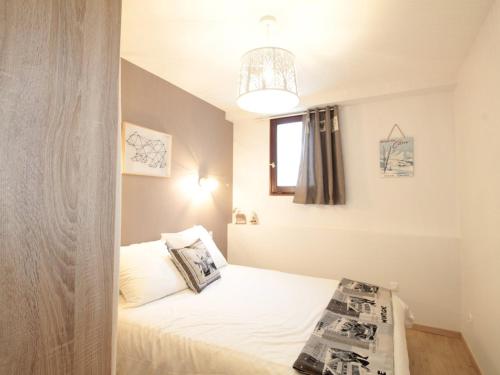 Un dormitorio pequeño con una cama con ventana. en Charme au centre d'Arâches : 2 pièces + coin montagne, 4/5 pers, proche pistes et commerces - FR-1-572-154, en Les Carroz d'Araches