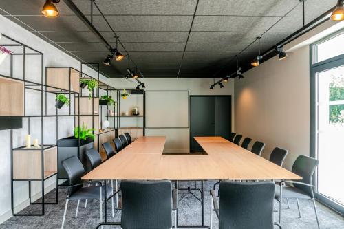 a conference room with a table and chairs at ibis Bordeaux Nord Carbon Blanc in Carbon-Blanc