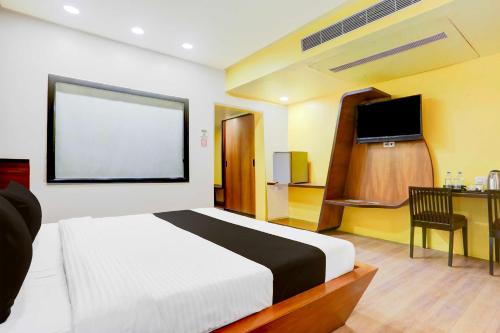 a bedroom with a bed and a desk and a television at Collection O Anand in Anand