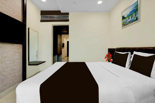a bedroom with a large black and white bed at Collection O Anu Hospital Elur Road in Vijayawāda