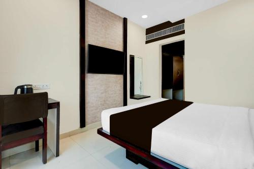 a bedroom with a bed and a chair at Collection O Anu Hospital Elur Road in Vijayawāda