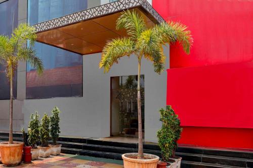 a building with palm trees in front of a red wall at Collection O Anu Hospital Elur Road in Vijayawāda