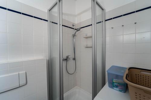 a shower with a glass door in a bathroom at Beautiful old building apartment in Dresden