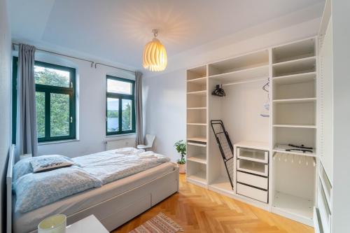 a bedroom with a bed and open shelves at Beautiful old building apartment in Dresden