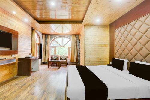 a bedroom with a large bed and a television at Hotel O Model Town Mall Road in Manāli