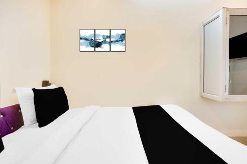 a bedroom with a black and white bed and a window at Collection O Jamrani in Haldwāni