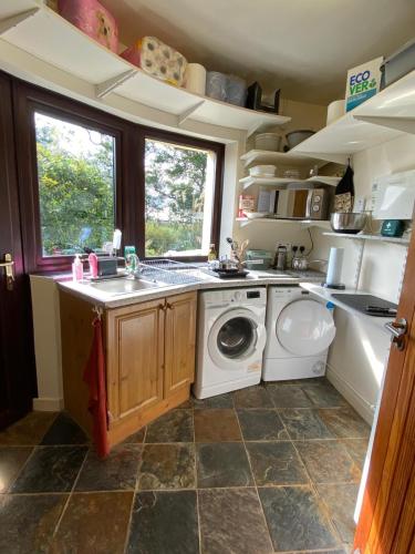 a kitchen with a sink and a washing machine at Private Stay in Scenic Home, near Portrush in Portstewart