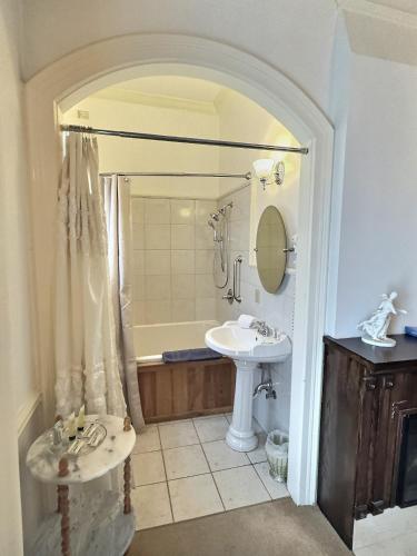 a bathroom with a sink and a tub and a toilet at Historic Sion Bass Guest House in Fort Wayne