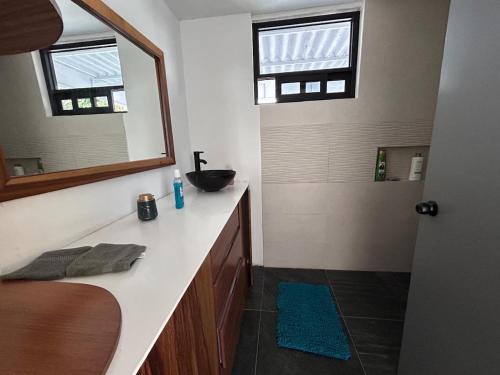 a bathroom with a sink and a mirror at Beautiful house nearby the AiFA in San Pedro Atzompa