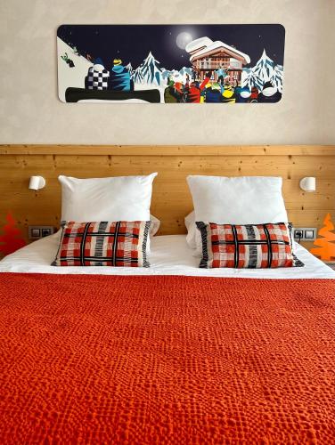 a bedroom with a bed with a red blanket and pillows at Hotel Base Camp Lodge - Bourg Saint Maurice in Bourg-Saint-Maurice