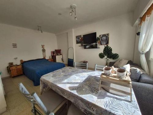 un salon avec une table et un lit dans l'établissement Departamento monoambiente Plaza Mitre, à Mar del Plata