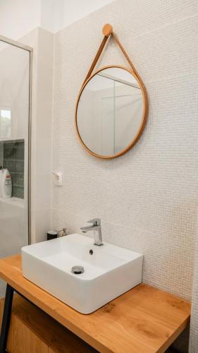 a bathroom with a white sink and a mirror at Bluevera seafront villa-Aidipsos bay in Gialtra