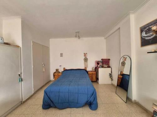 une chambre avec un lit bleu et un miroir dans l'établissement Departamento monoambiente Plaza Mitre, à Mar del Plata