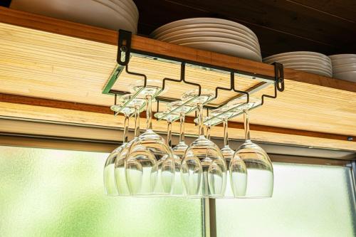 a bunch of wine glasses hanging from a chandelier at 阿蘇あそび バーベキューオプション 便利な立地 スーパーやレストラン充実 貸切 内牧温泉 最大10名 in Aso
