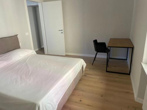 a bedroom with a bed and a table and a chair at Vivic Home Monforte in Monforte dʼAlba