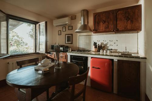 a kitchen with a table and a red refrigerator at Agriturismo Le Macchie in Monticchiello