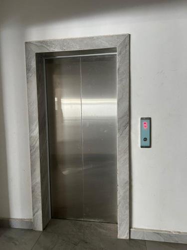 a metal elevator door in a building with a red button at Caster two bedrooms apartment jkia in Nairobi