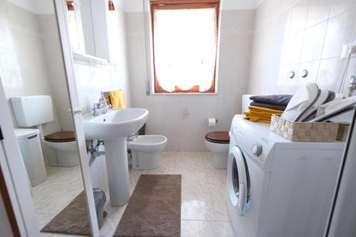 a white bathroom with a sink and a washing machine at Estar Sogni by PortofinoVacanze in Rapallo