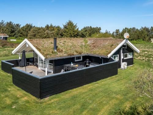 a house with a grass roof with a deck at Holiday Home Eddi - 550m from the sea by Interhome in Løkken