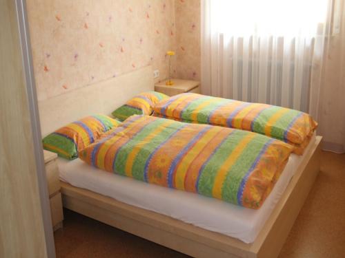 1 Schlafzimmer mit 2 Betten und bunten Decken in der Unterkunft Ferienwohnung am Hauskopf in Oppenau